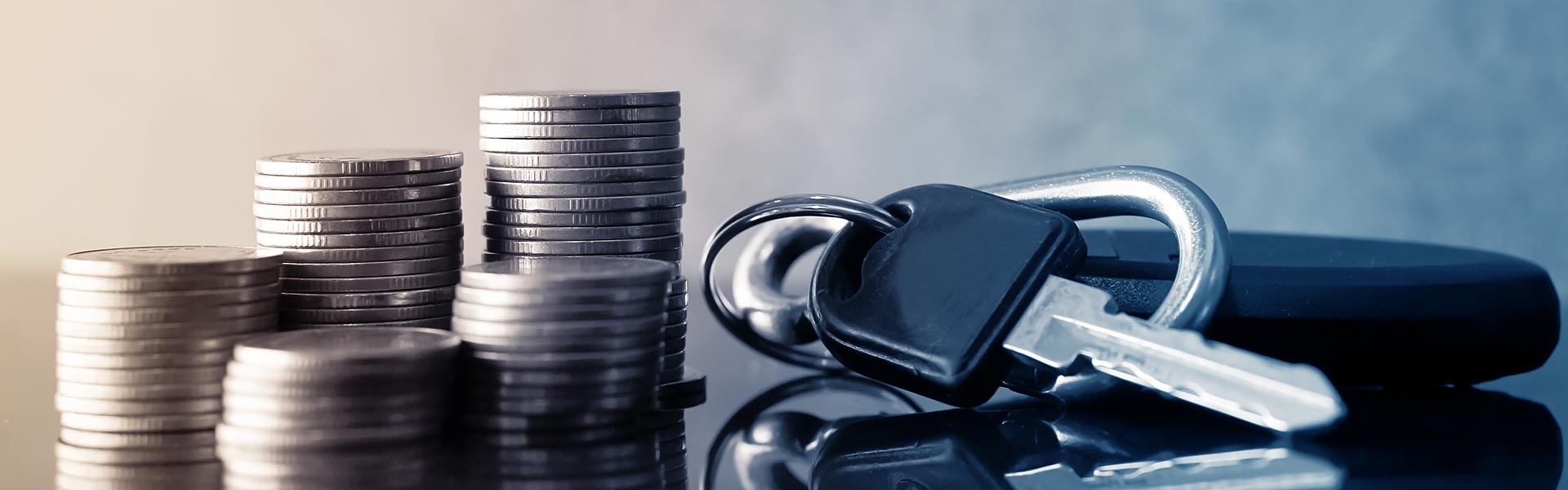Stacked coins next to a car key.
